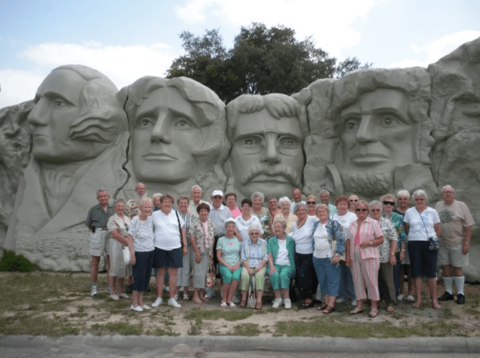 Photo of a group in front of a replica Mount Rushmore