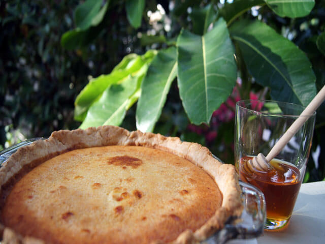 Photo of a pie next to honey