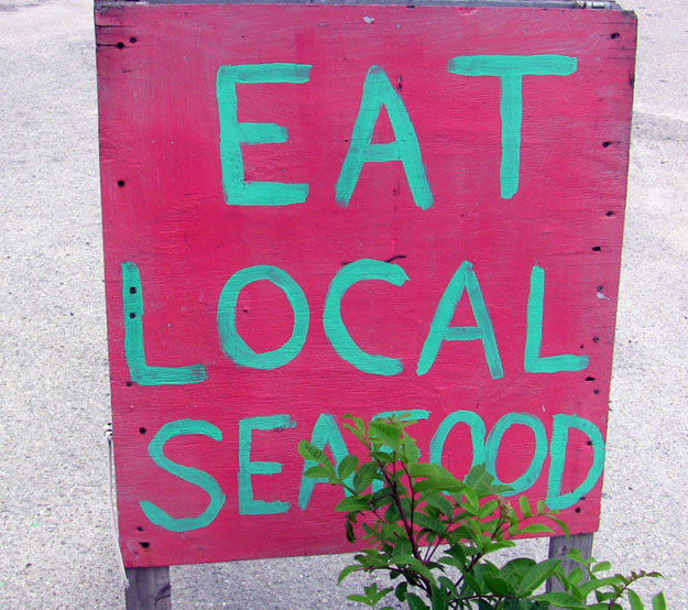 Pink sign that says Eat Local Seafood