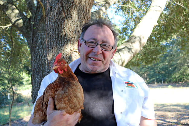 Photo of a man holding a chicken