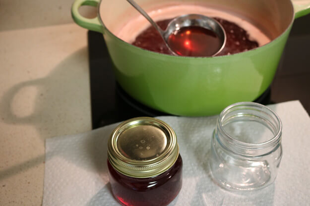 Beautyberry Juice being poured into jars 