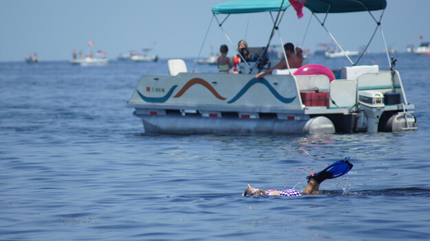 Photo of a person scalloping near a boat