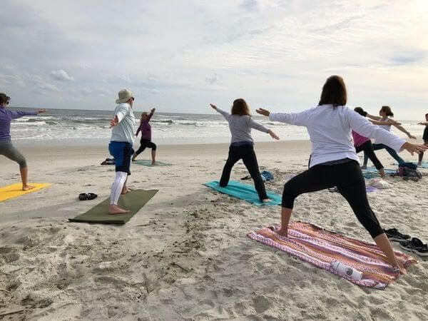 Photo of people doing yoga on the beach