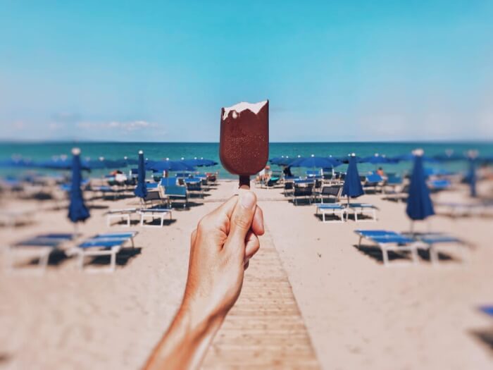Person holding ice cream at the beach