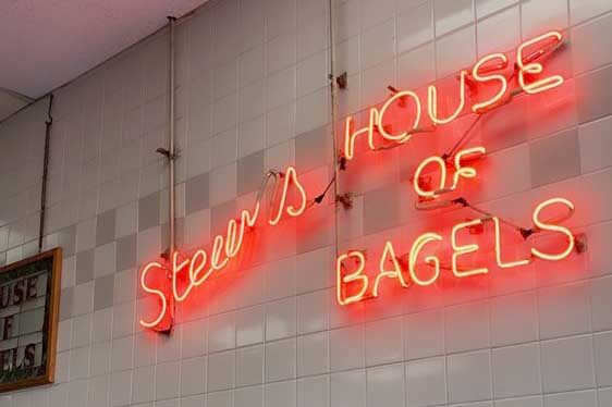 Sign on a wall that says Stew's House of Bagels. 