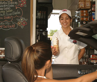 Photo of a woman serving ice cream to a woman in a car