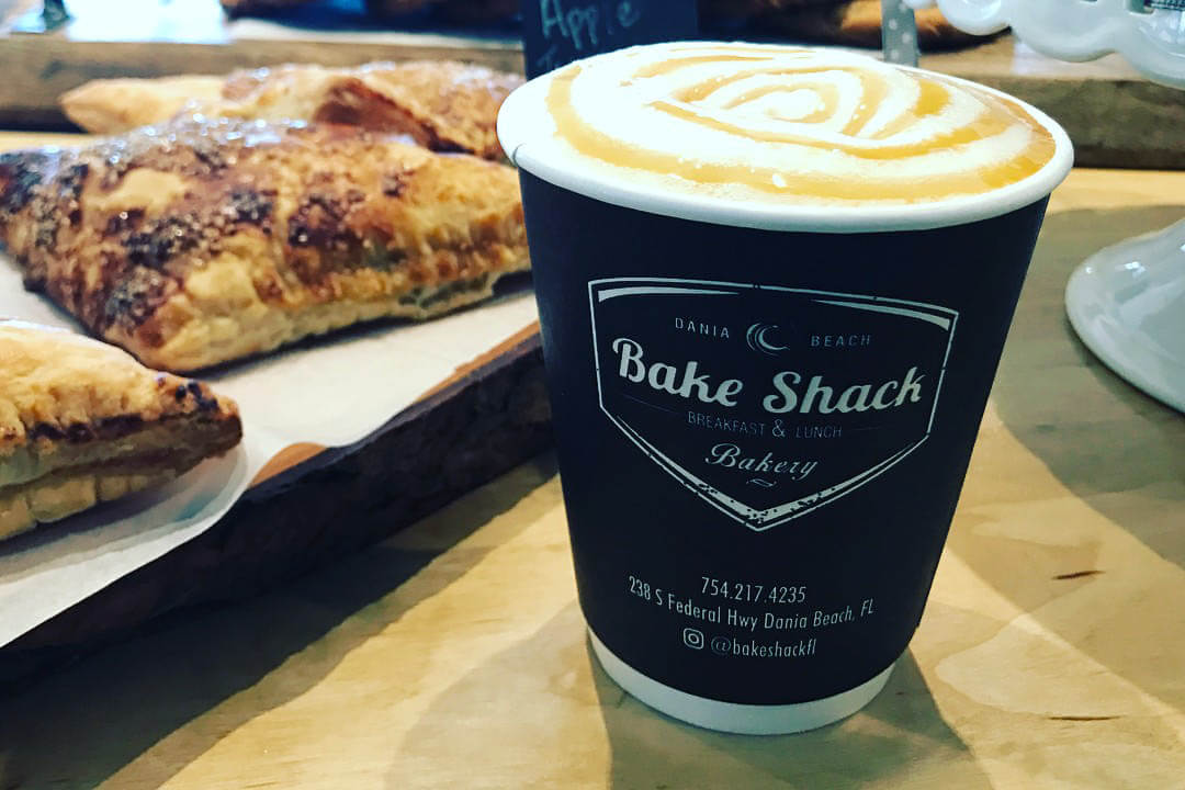 Coffee at the Bake Shack with pastries behind it. 
