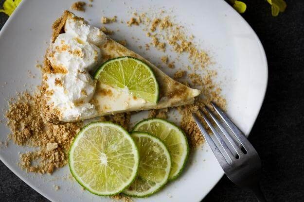 Key lime pie on a plate with limes. 