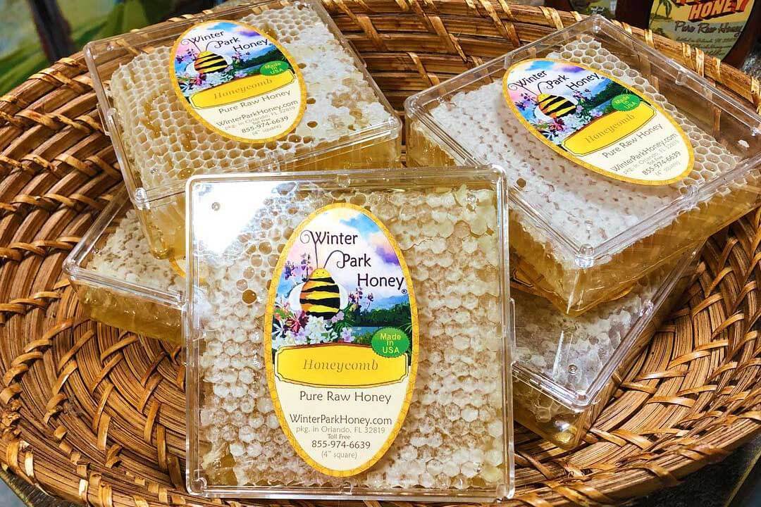 Honeycomb in containers with labels that read Winter Park Honey.