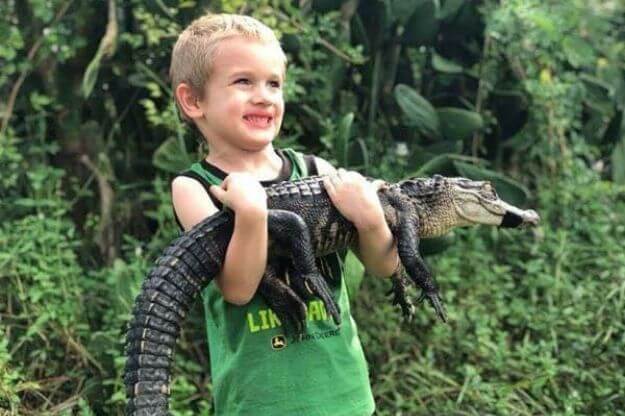 Photo of a boy holding an alligator one of the Animal Encounters in Florida