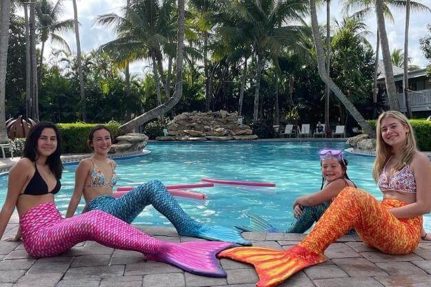 Mermaids on the edge of a pool. 