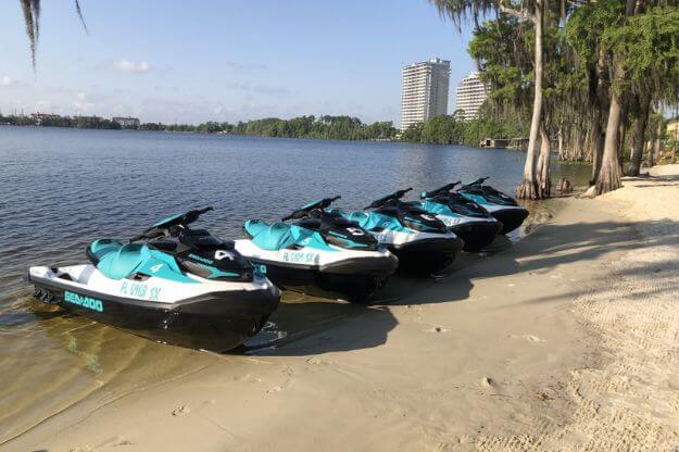 Jet skis parked on shore. 