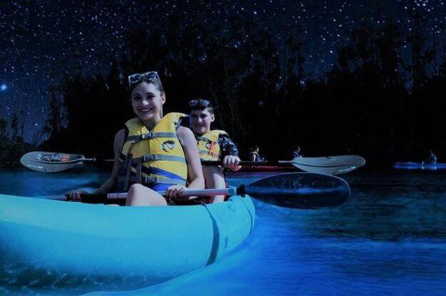 two people kayaking at night