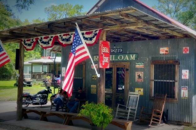 Photo of Richloam General Store exterior with rocking chairs and US flags