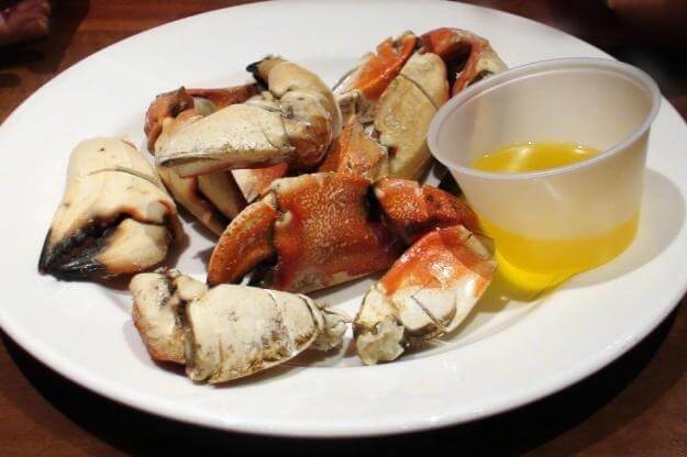 Photo of fresh Florida stone crab claws with butter on plate