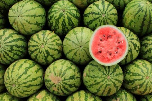 Photo of round watermelons and one cut in half