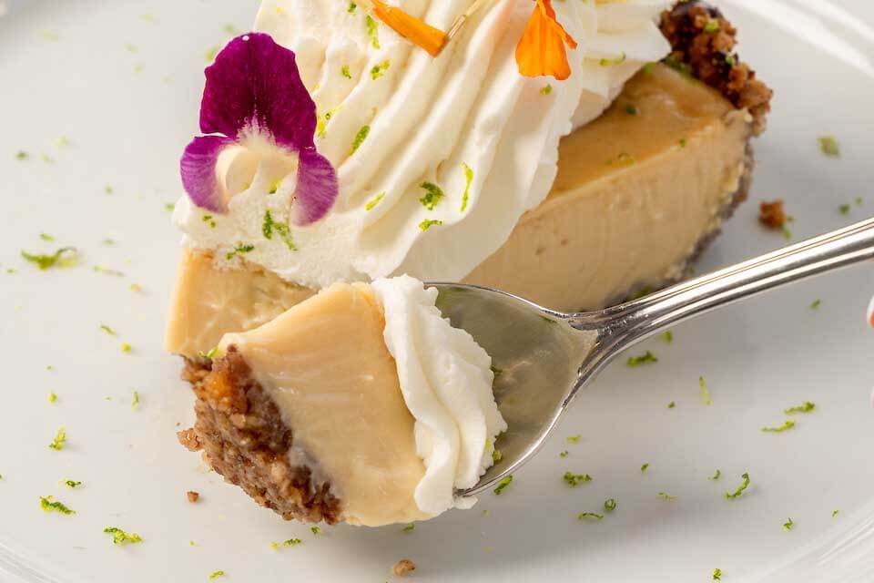 Key Lime pie slice with a bite on a fork