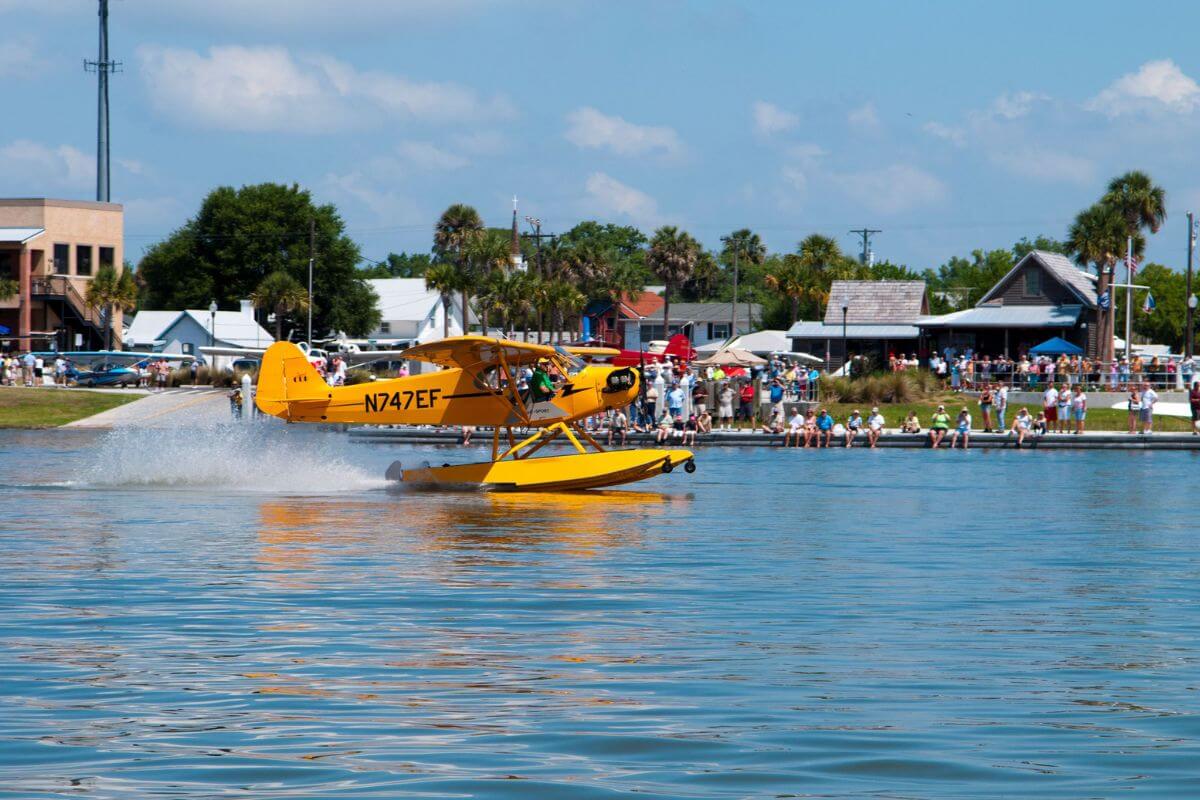Yellow seaplane on water. 