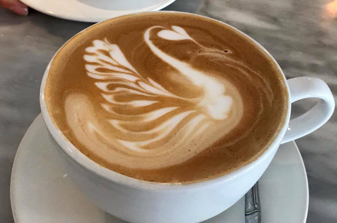 Swan coffee art on top of a cup of coffee. 