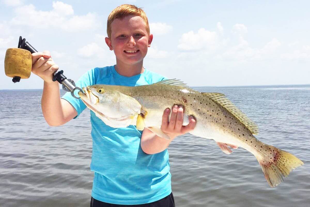Boy holding a large fish.