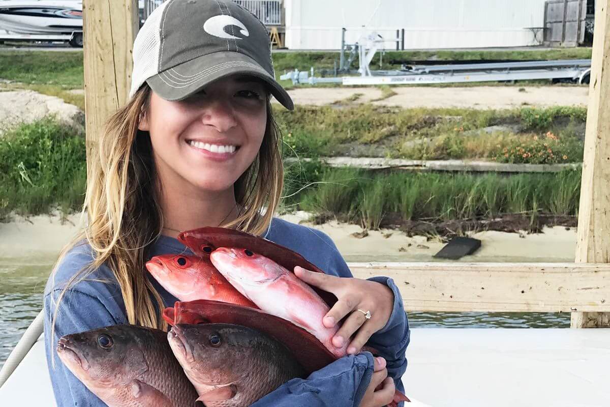 Girl holding fish at one of the best fishing spots in Destin.