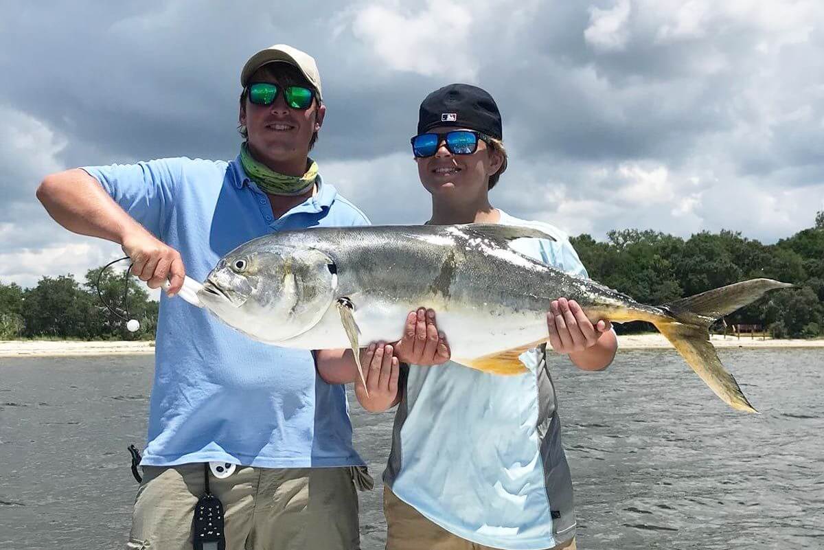 Tow boys holding a large fish.