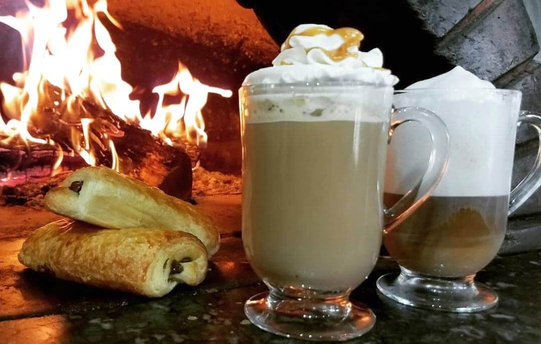 Coffee and treats in front of a fire. 