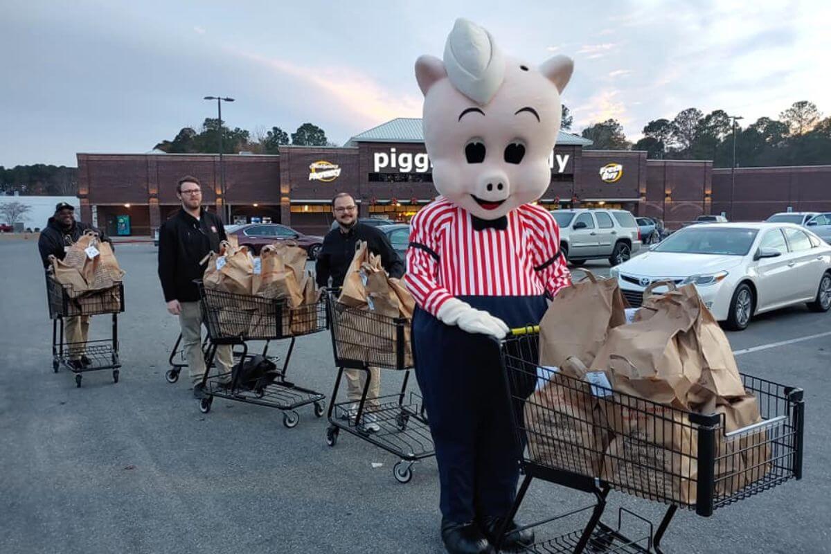 Piggly Wiggly mascot pushing shopping cart.