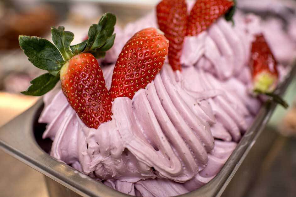Strawberry ice cream with strawberries on top. 