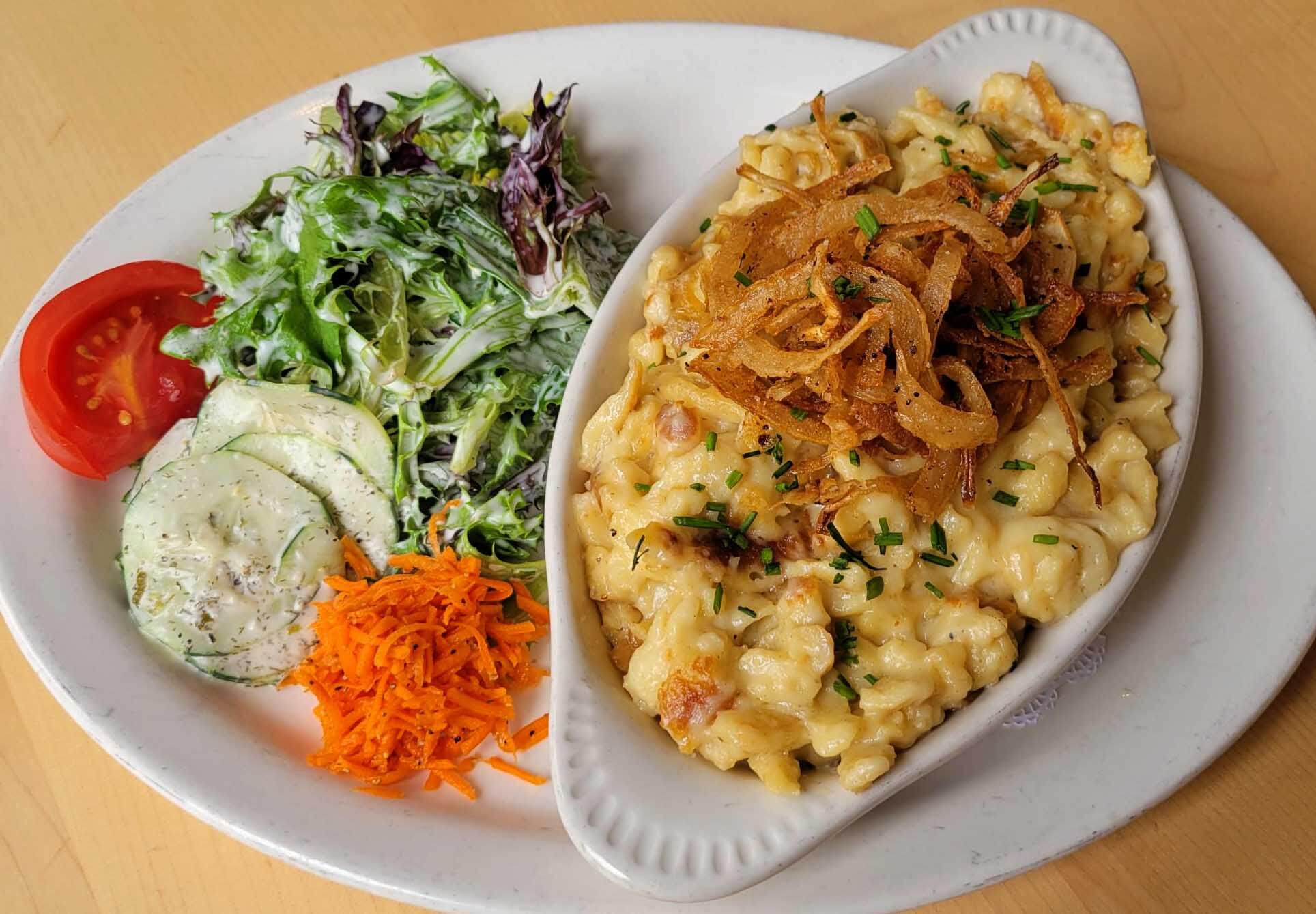 Macaronie and cheese and a salad on a plate.