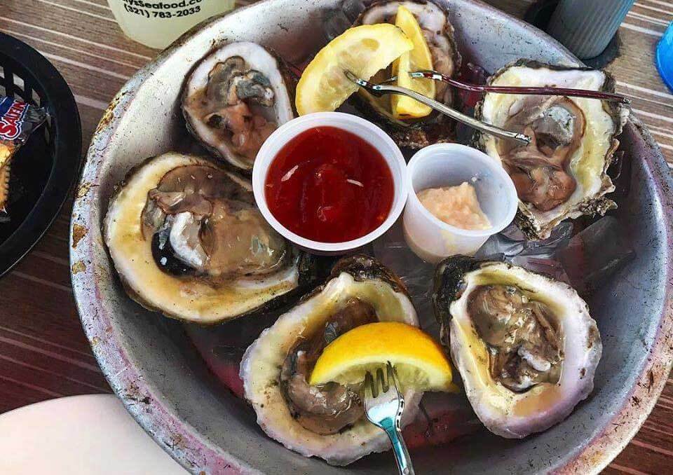 Oysters with lemon and dips on a tray. 