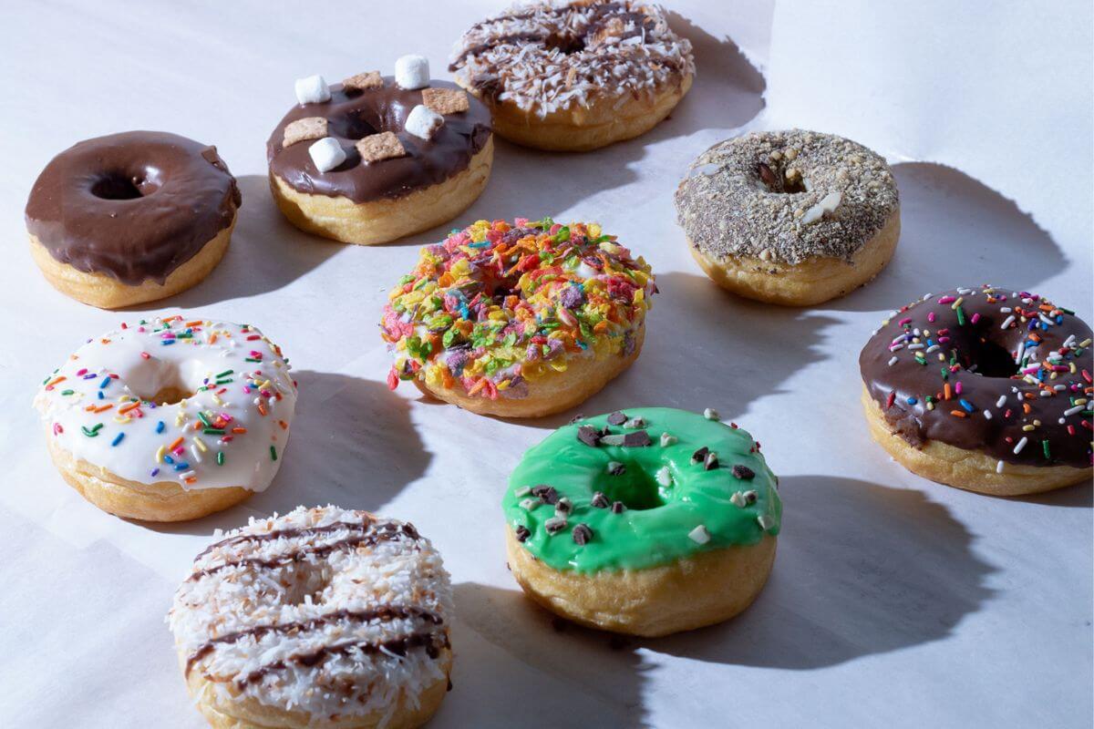 Variety of donuts on a white tabletop. 