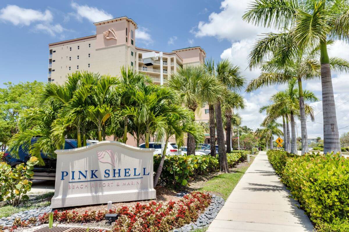Resort exterior with a sign in front that reads Pink Shell. 