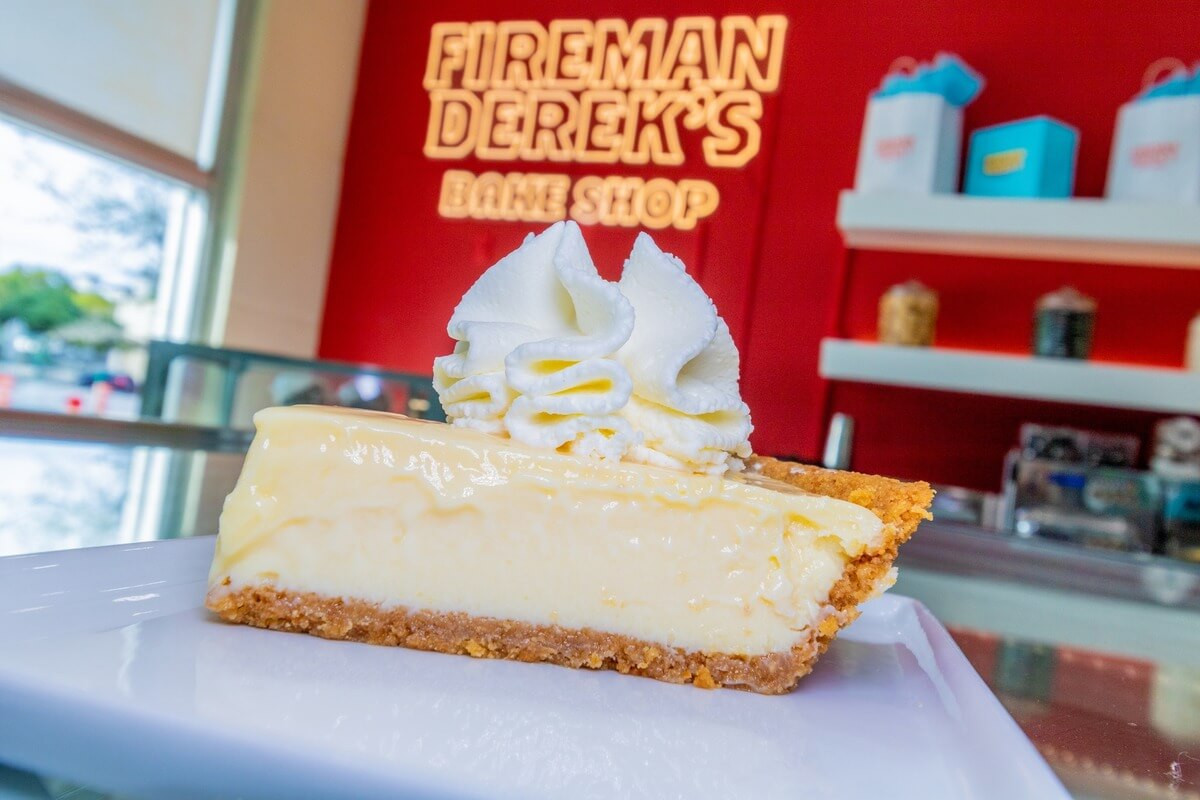 Piece of pie with a sign behind it that reads Firemand Derek's Bake Shop. 
