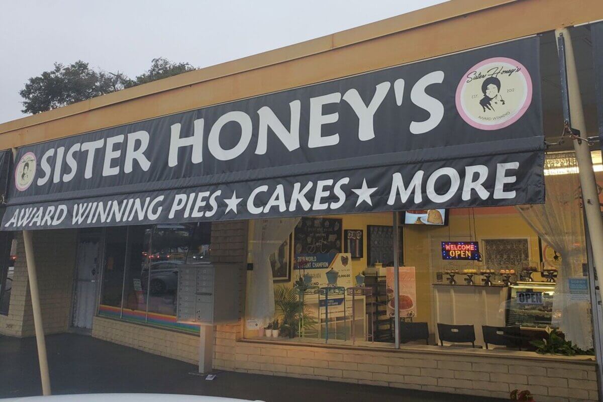 Bakery exterior with a sign that reads Sister Honey's Award Winning Pies Cakes More. 