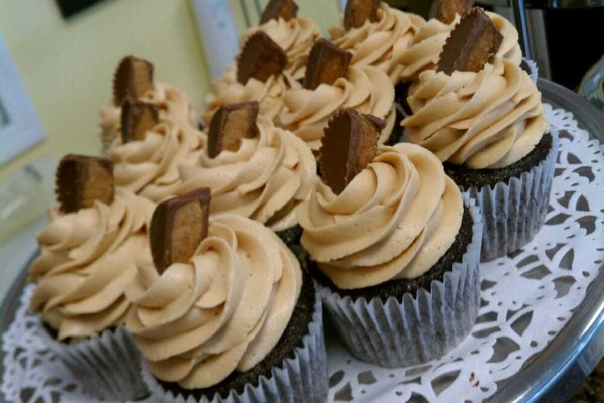 Cupcakes with peanut butter cups on top of them. 