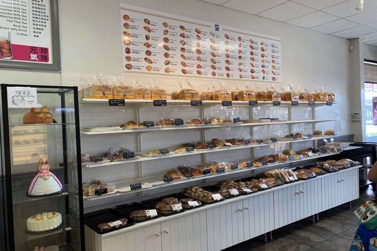 Inside of a bakery with a variety of food on display. 