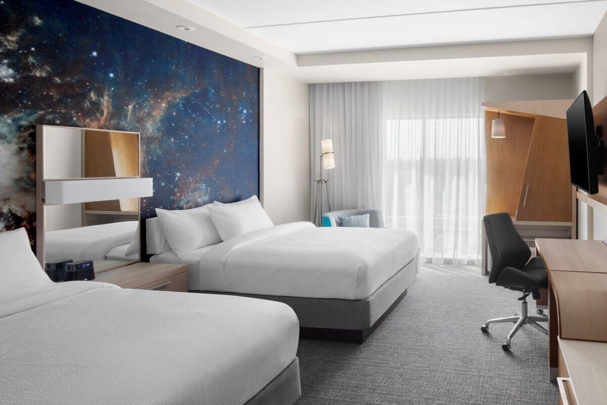 Room at a hotel with a space themed wall decoration. 