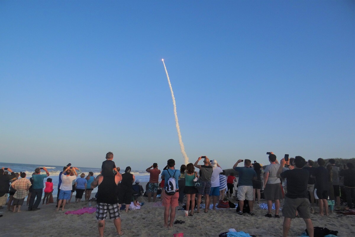 People watching rocket launch from the beach. 