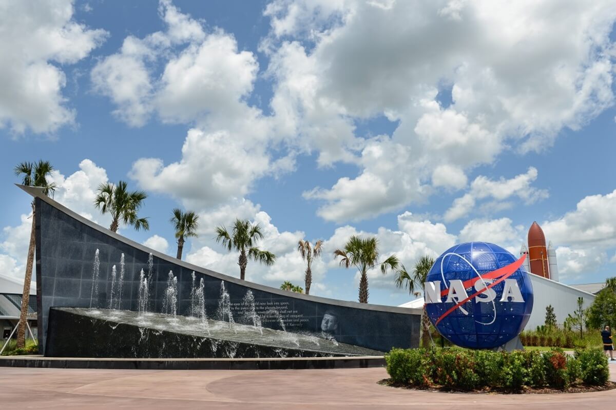 Nasa Globe next to a large fountain on a sunny day. 