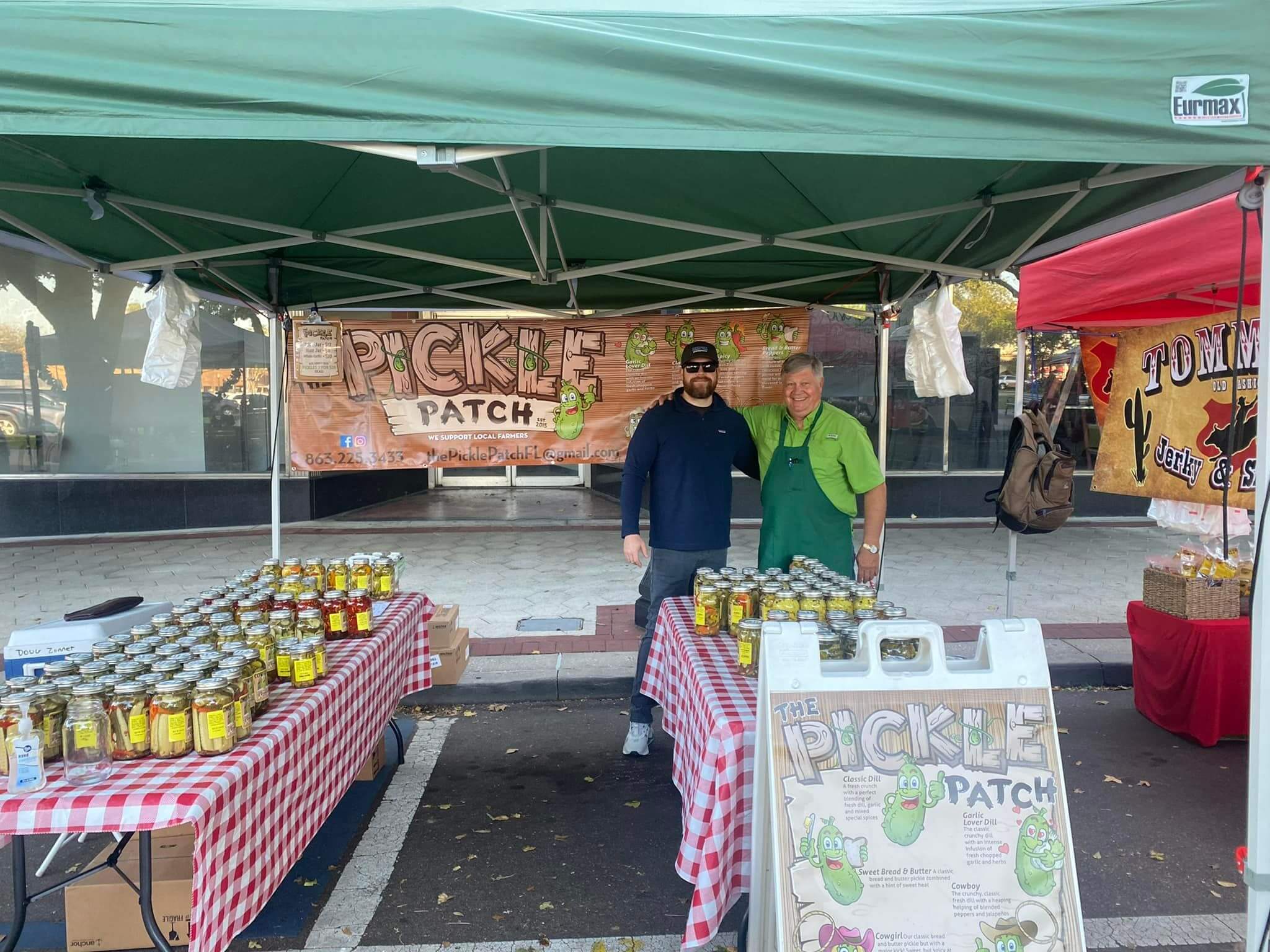 Two men in the pickle patch pickle booth. 
