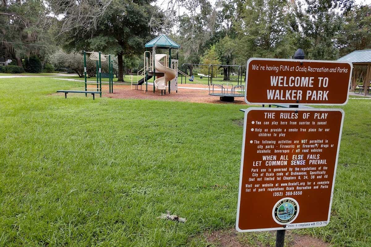 Sign that reads Welcome to Walker Park in frontof a playground.
