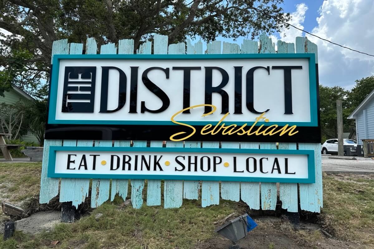 Shop sign reading The District Sabastian Eat Drink Shop Local. 