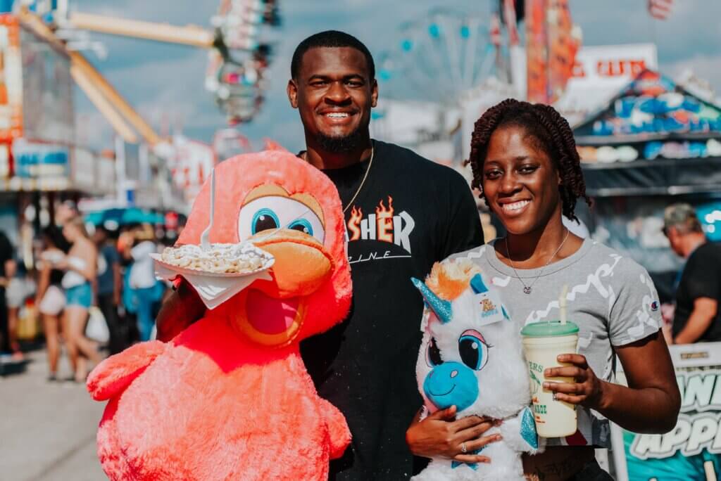 game winners with large stuffed animals at fair