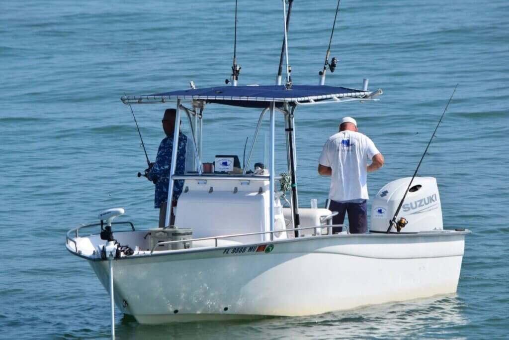 two men fishing on white boat 